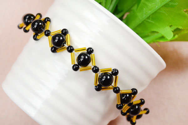 دستبند لوزی ساخته شده توسط مهره‌های سیاه و طلایی